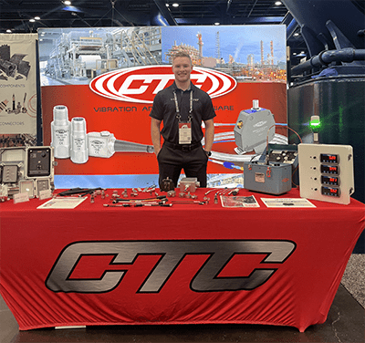 A CTC Sales Team member wearing a black CTC polo shirt at a trade show, standing in front of a blue PRO Line banner and a red CTC Line banner