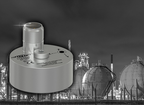 miniature circular triaxial accelerometer in front of industrial background photo