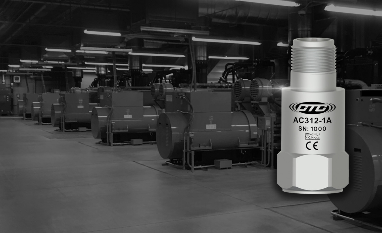 CTC's AC312 top exit, low power vibration monitoring sensor in front of a black and white photograph of industrial motors