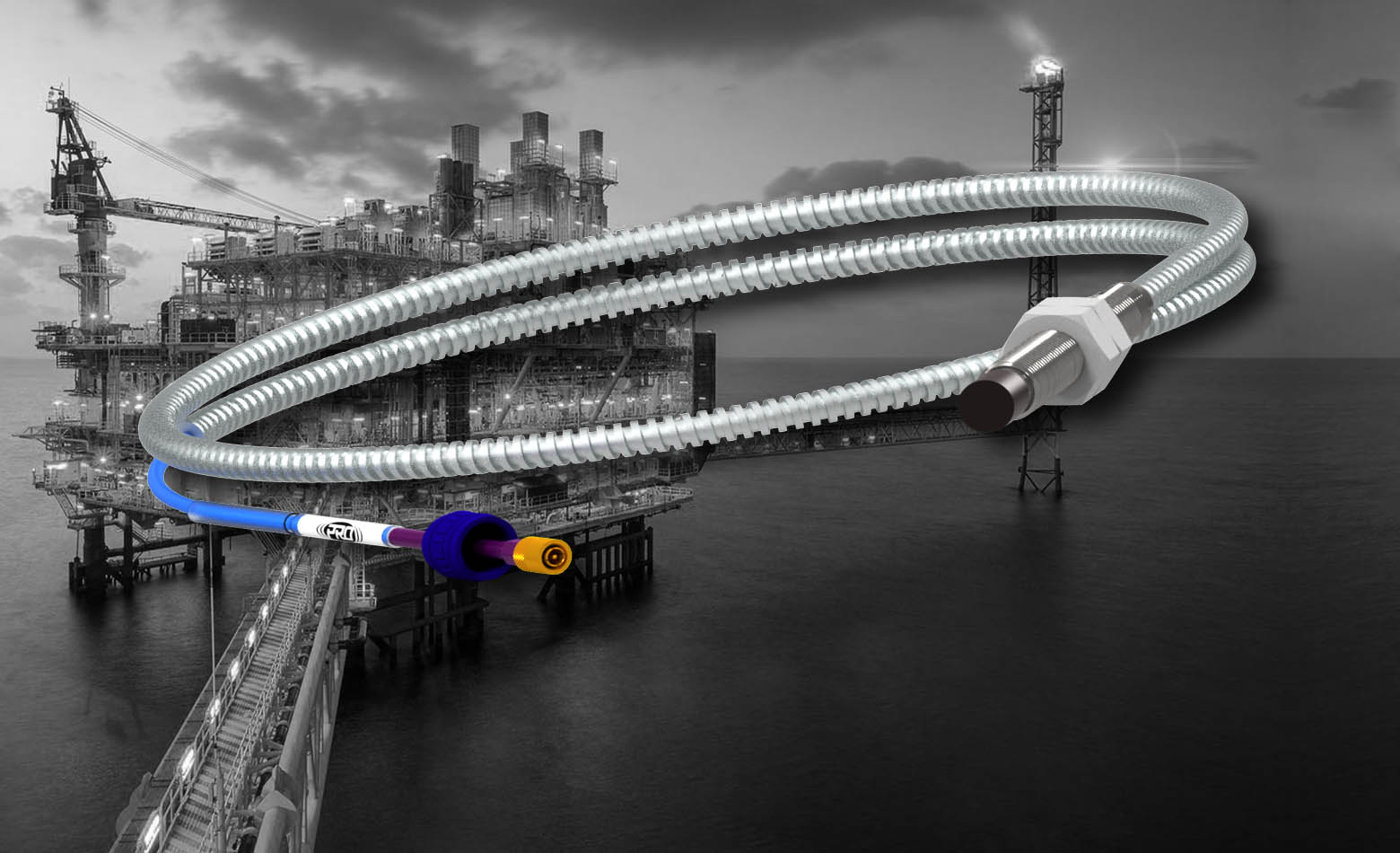 An 8 millimeter PRO Line armored proximity probe extension cable in front of a black and white photograph of an off-shore oil rig